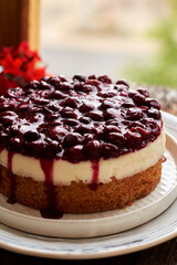 Cherry cake. Breton shortcrust pastry. Cheesecake. Cherry sauce. Side view. Wooden background.