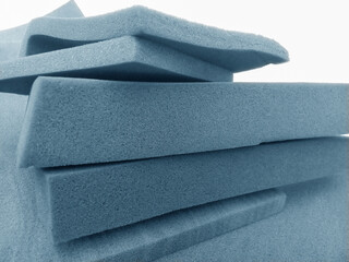 stacks of rectangular pastel blue foam material of different thicknesses are arranged crosswise....