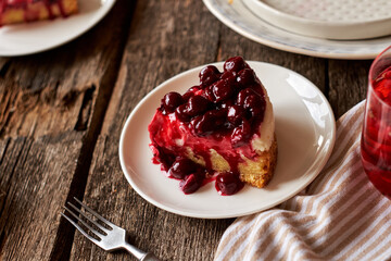 Cherry cake. Breton shortcrust pastry. Cheesecake. Cherry sauce. Side view. Wooden background. Piece of cake