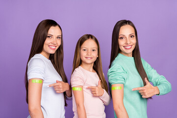 Photo of excited confident mommy two daughters wear pullovers pointing vaccination patches isolated...