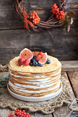Honey cake decorated with blueberries, figs and strawberries. Side view. Layer cake.