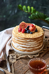 Honey cake decorated with blueberries, figs and strawberries. Side view. Layer cake.