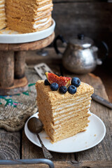 Honey cake decorated with blueberries, figs and strawberries. Side view. Layer cake.