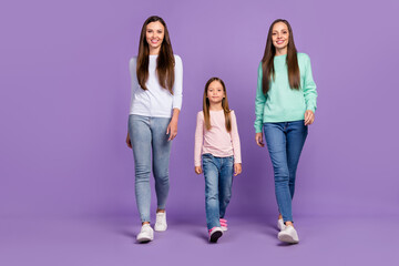 Naklejka premium Photo of charming shiny mommy two daughters wear casual pullovers walking smiling isolated violet color background