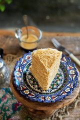 Piece of honey cake. Wooden background, side view. Layer cake.