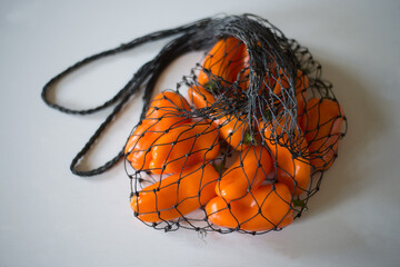 Orange pepper in a mesh natural eco-bag string bag.
