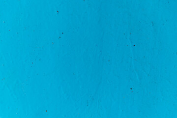 Blue paint on the wall.Rough uneven surface.