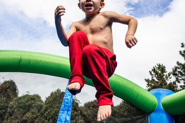 Young boy jumping in the air in a bouncy house