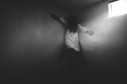 Scary ghost girl clinging to the corner of the walls