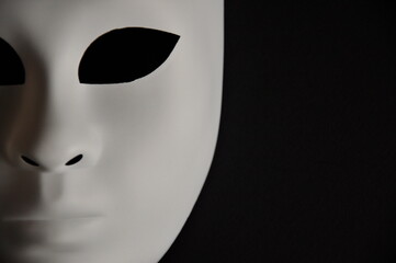 White theatrical mask on black background
