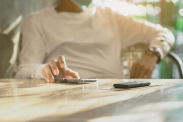 Queue Wireless Calling System Restaurant or Pager Customers System with invoice on table with blur image of man wear protective face mask using cellphone in background. Alarm signal when food is done.