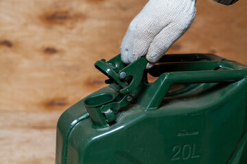 Hand opens iron canister on wooden background