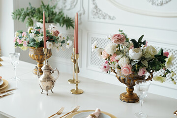 Beautiful table set for an event party or wedding reception with candels and flowers. Restaurant interior. Selective focus.