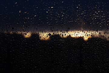 The background of a wet window at sunset