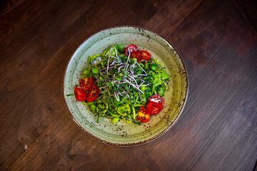 Healthy vegetable salad of fresh tomato, cucumber, onion, spinach, lettuce and sesame on plate. Diet menu.