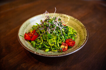 Healthy vegetable salad of fresh tomato, cucumber, onion, spinach, lettuce and sesame on plate. Diet menu.