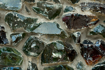 Glass fiber melt multicolored blocks cemented on facade concrete wall as modern architectural decorative decision of broken glass recycling. Durable, weatherproof outdoor molten glass stones texture