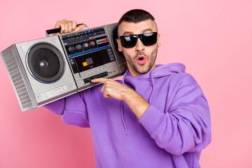 Photo of impressed millennial brunet guy listen boom box wear eyewear hoodie isolated on pink background © deagreez