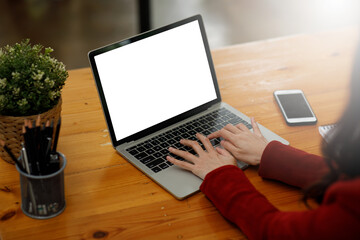 Woman hand using a laptop and sitting on the office in the house, mock-up of a blank screen for the application.