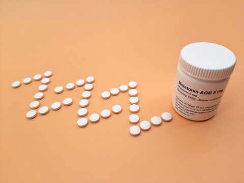 A pill jar of Melatonin and the pills spelling out Zzzzz for sleep beside the jar.