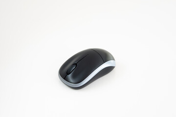 Small black wireless computer mouse isolated on white background. Close up studio shot, no people