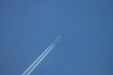 View of a commercial airplane high in the sky with the trails of the turbines