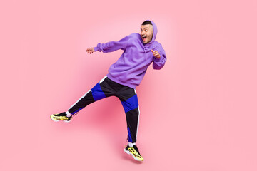 Fototapeta na wymiar Full length photo of young cheerful guy jump amazed look empty space isolated over pink color background