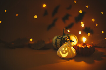 Happy Halloween. Pumpkin, glowing jack o lantern, burning candle, spider on dark orange background...