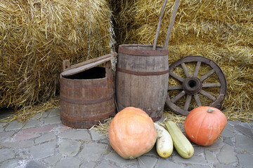 Old burrels, pumpkings, wheel and straw piles on seasonal market.