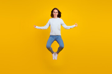 Fototapeta na wymiar Full body photo of happy calm young woman jump wear glasses asana isolated on yellow color background