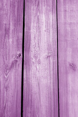 Wall made of uncutted weathered wood boards in purple color.