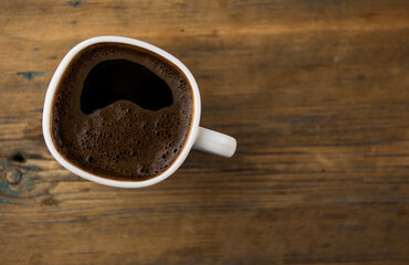 Top view of coffee cup on a wood background with copy space.