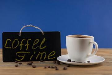 A cup of coffee and blackboard with inscription 