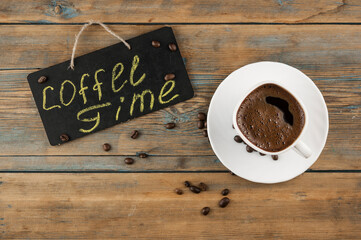 A cup of coffee and blackboard with inscription 