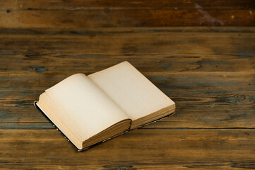Fototapeta premium an old open book with blank pages lies on a wooden table