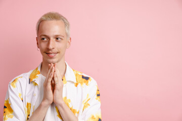 Young blonde man in shirt gesturing and smiling at camera