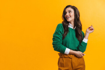 Young brunette woman in sweater smiling and looking aside
