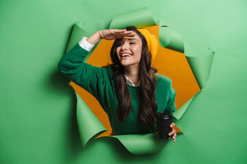 Young white smiling woman peeking out hole