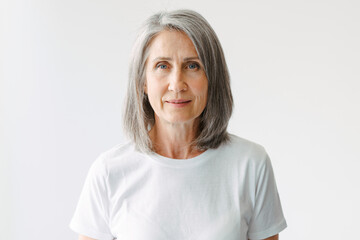 Grey senior woman in t-shirt posing and looking at camera