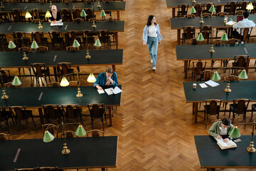 Young european students doing homework at library