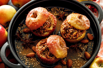 Baked apples stuffed with nuts, honey and spices in a cast iron baking dish, close-up view