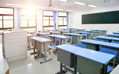Fototapeta na wymiar Empty classroom with blue desks and chairs