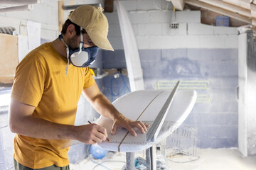Surfboard Modeling Workshop - Man perfecting the modeling of a surfboard