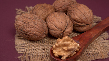 closeup photo of a walnut seed in wooden bowl. Food that is good for brain and lower risk of heart disease.