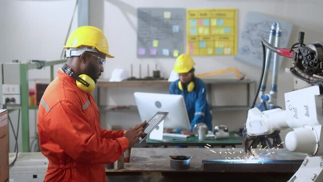 specialist technical engineer hand input programing code data computing to manage movement work flow of robotarm welding machinery in workshop modern factory smart industrial manufacture concept