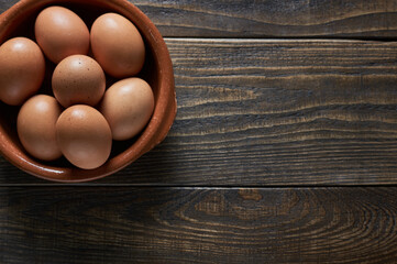 rustic dark wood background with eggs on a corner