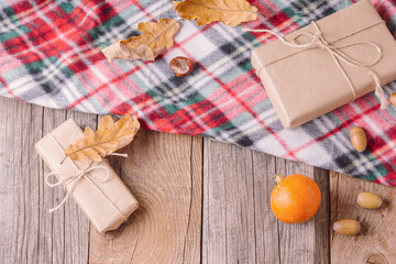 Thanksgiving frame. Autumn composition on wooden background. Gift boxes, plaid and pumpkin