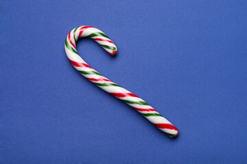 Sweet Christmas candy cane on blue background, top view