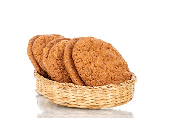 Several fresh oatmeal cookies with straw dishes, close-up, isolated on white.