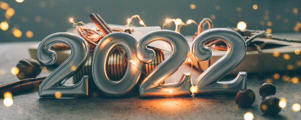 Christmas and New Year card. Number 2022 on holiday background. Christmas lights bokeh background....
